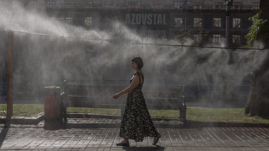Жінка проходить повз системи розпилення води для охолодження в Києві 30 червня 2026 рік