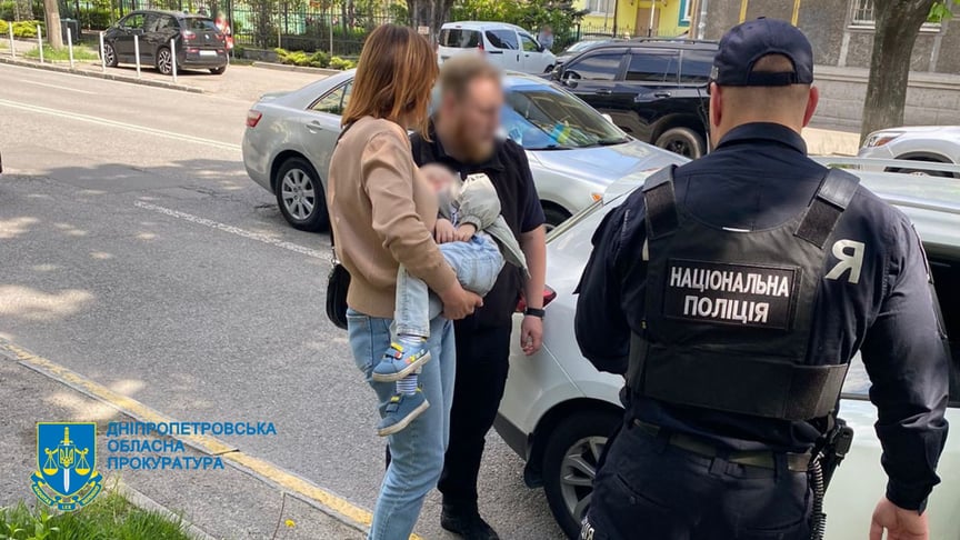 Дитина на руках співробітниці міграційної служби