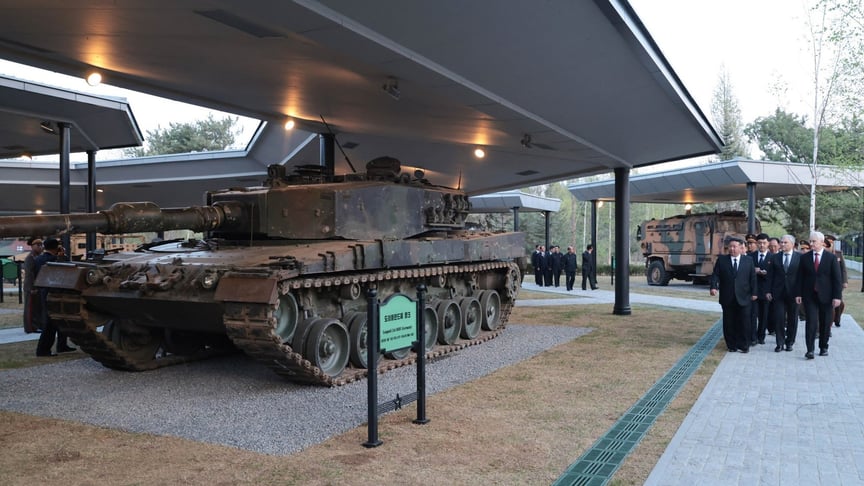 російська делегація на чолі з главою Міноборони рф Бєлоусовим у КНДР на відкритті музею. Поруч, ймовірно, німецький танк Leopard 2A4