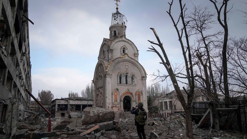 Український військовослужбовець фотографує пошкоджену після обстрілу церкву в мікрорайоні Маріуполя, 10 березня 2022 року