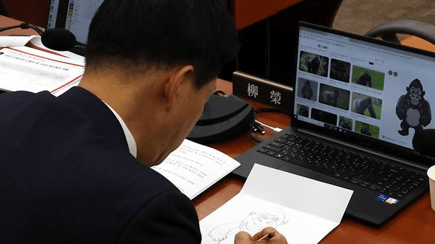 Депутат Південної Кореї Ю Йон-ха малює горилу під час засідання Депутат Південної Кореї Ю Йон-ха малює горилу під час засідання