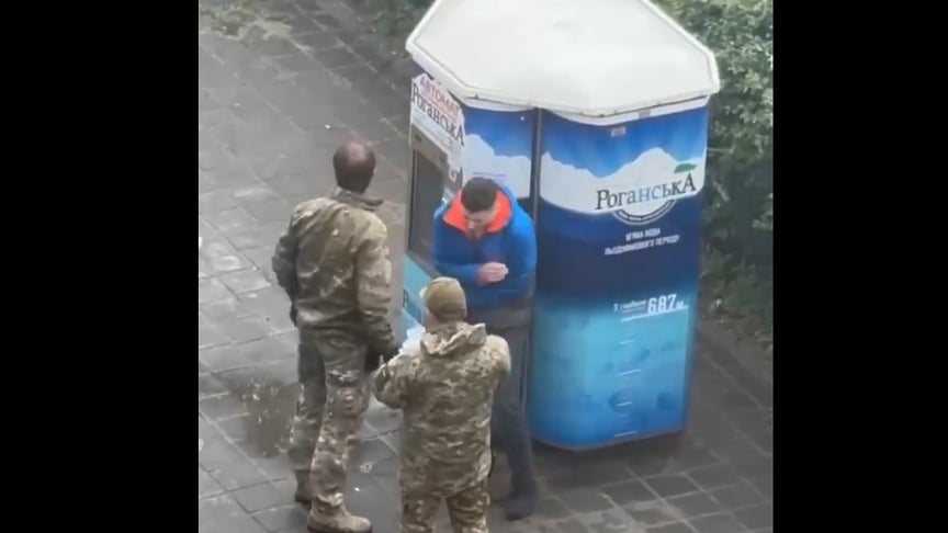 Військові Харківського ТЦК перевіряють документи в чоловіка, якого згодом вдарили