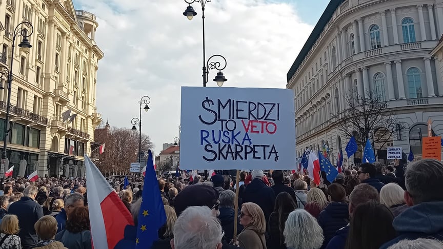 Протестувальники тримають плакат із надписом «Це вето тхне російською шкарпеткою», Варшава, Польща, 15 березня 2026 року Протестувальники тримають плакат із надписом «Це вето тхне російською шкарпеткою», Варшава, Польща, 15 березня 2026 року