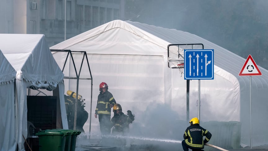 Пожежники гасять пожежу в наметі проурядового табору біля будівлі парламенту Сербії в Белграді, 22 жовтня 2025 року