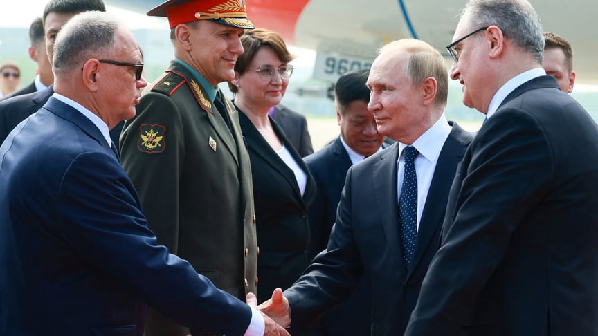 глава росії володимир путін тисне руку торговому представнику росії в Китаї Олексію Дахновському разом із послом р осії в Китаї Ігорем Моргуловим (праворуч) після його прибуття до аеропорту Тяньцзіня, 31 серпня 2025 року