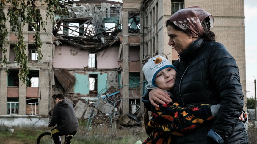 Ілюстративне фото. Мати обіймає доньку на покинутій ділянці їхньої зруйнованої школи в Костянтинівці Донецької області, 13 жовтня 2022 року