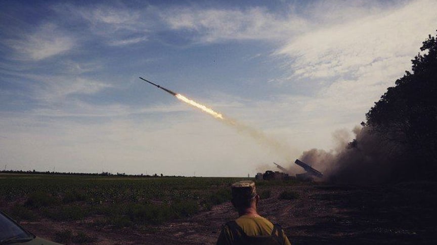 Ukrainian soldier against the background of a launched rocket. Illustrative photo