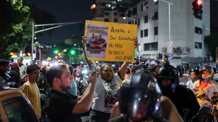 Родичі політичних в'язнів тримають плакати з вимогою звільнити політв'язнів перед центром утримання під вартою Ель-Гелікоїде в Каракасі, 8 лютого 2026 року