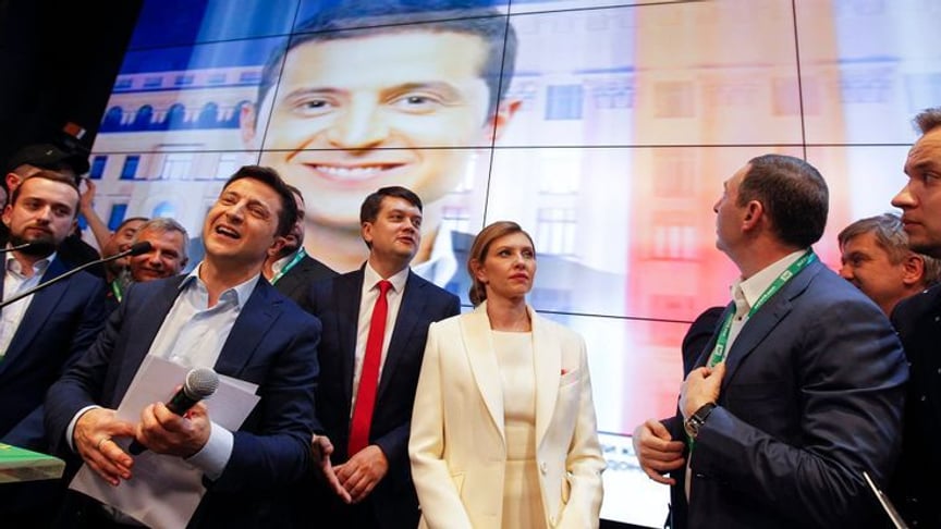 Кандидат в президенты Украины Владимир Зеленский (в центре) с женой и членами своей команды в штабе после объявления экзит-полов, Киев, 21 апреля 2019 года