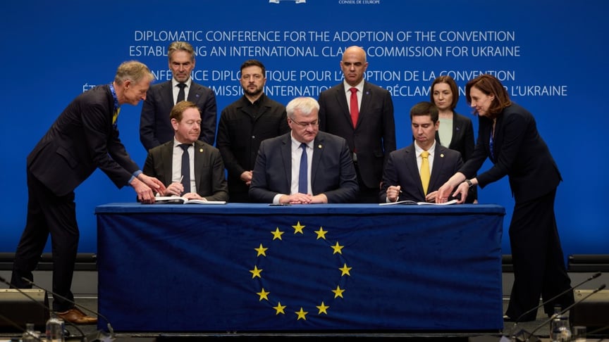 Міністр закордонних справи України Андрій Сибіга (у центрі) підписує конвенцію у Гаазі, 16 грудня 2025 року