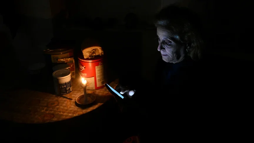 Ілюстративне фото. Жінка перевіряє свій мобільний телефон під час відключення електроенергії в районі Луяно в Гавані, 28 січня 2026 року