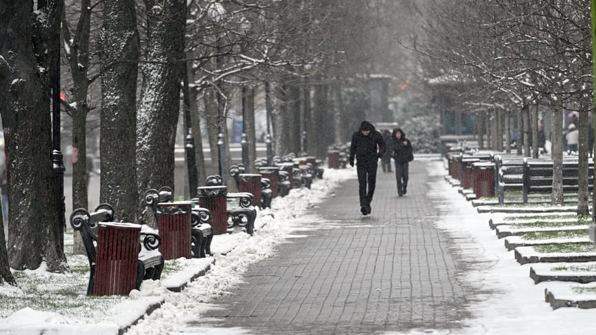 Люди йдуть вулицею під час снігопаду в Києві, 14 грудня 2025 року