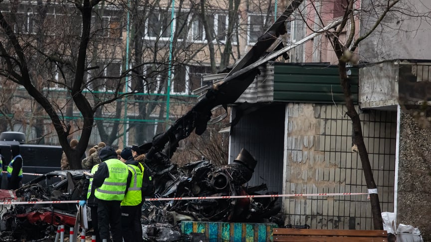 Поліціянти стоять біля уламків гелікоптера, який розбився на території дошкільного закладу у Броварах, 18 січня 2023 року