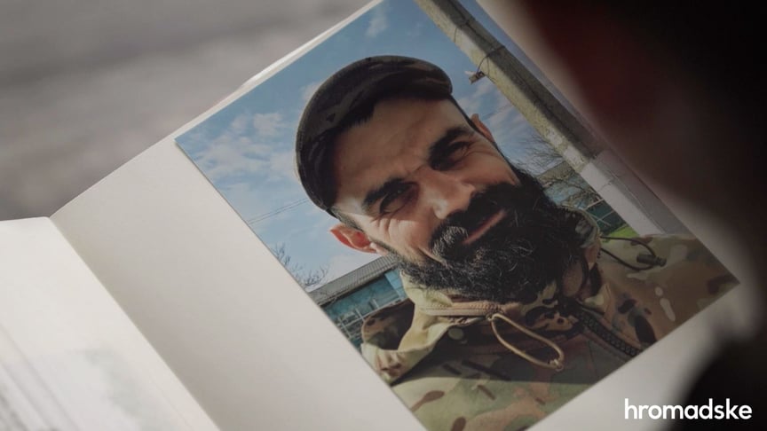Дружина Євгена Лєпіна Оля гортає фотоальбом зі світлинами чоловіка
