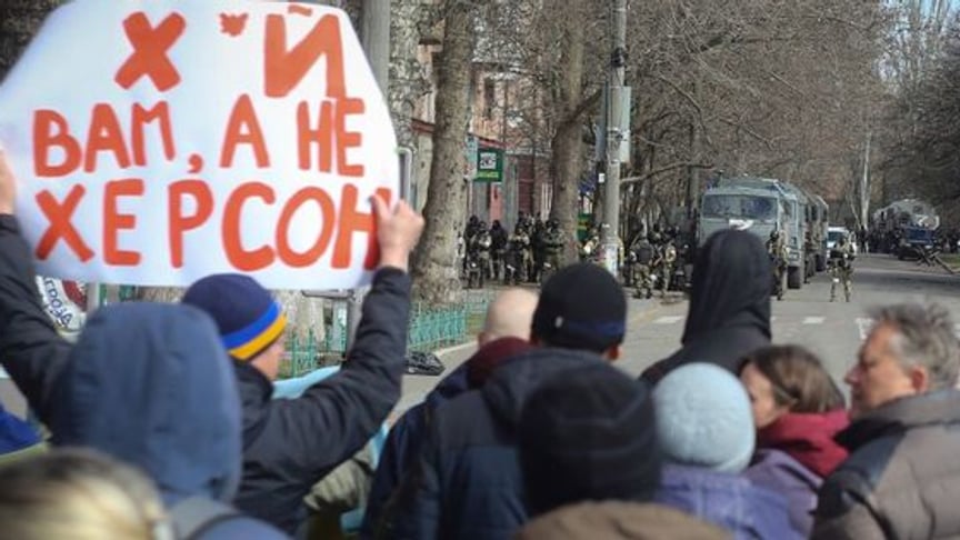 People stand in front of Russian troops during a rally against the Russian occupation in Kherson, March 14, 2022