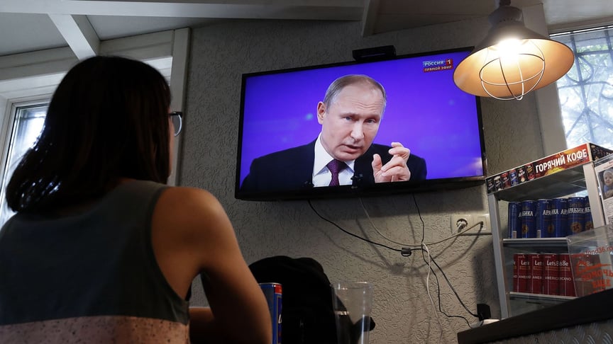 Посетительница в баре смотрит по телевизору «прямую линию» с Владимиром Путиным, Москва, Россия, 20 июня 2019 года