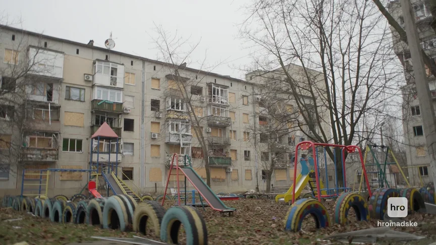 Многоэтажка с выбитыми окнами и детская площадка в Покровске, декабрь 2024 года