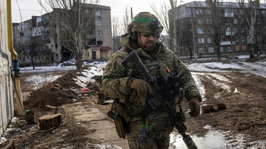 Український військовий «Дієтолог» підрозділу швидкого реагування (КОРД) патрулює вулицю в Бахмуті, 24 лютого 2023 року
