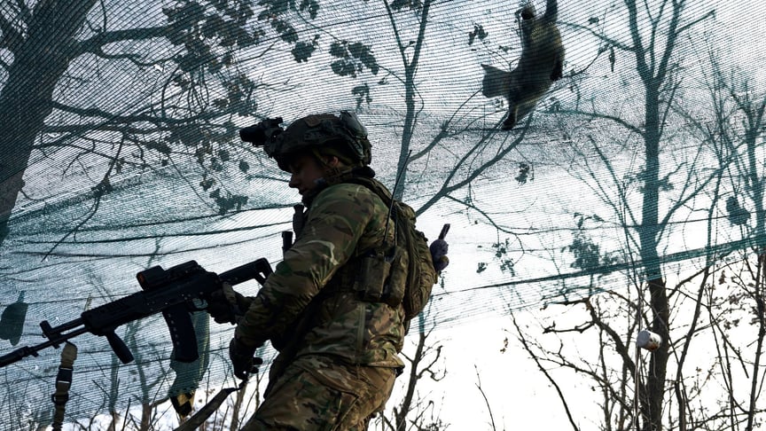 A cat walks on a net as a Ukrainian soldier takes a position during fighting with Russian occupiers near Marinka, Donetsk Oblast, December 23, 2022