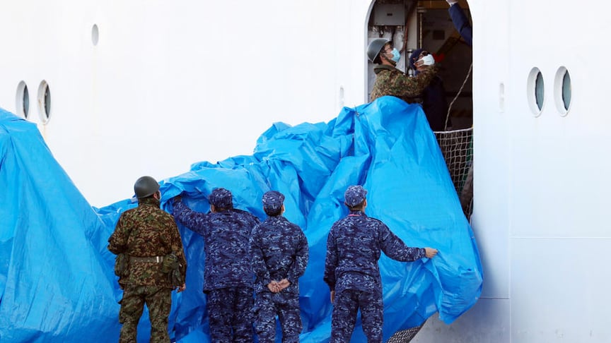 Japan Self-Defense Force (JSDF) members wearing masks prepare the entrance of the Diamond Princess cruise ship docked at the Daikoku Pier Cruise Terminal in Yokohama, south of Tokyo, Japan, 10 February 2020.