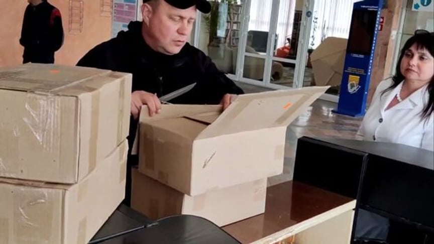 Депутат російської держдуми Ігор Костюкевич у херсонській бібліотеці відкриває коробки з книжками «від путіна»