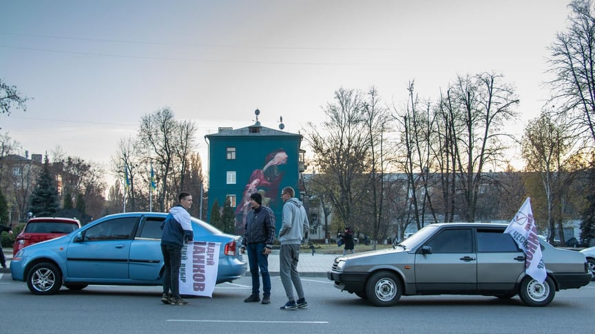 Молодые люди, агитирующие за Андрея Панкова, сворачивают агитационные флаги в конце рабочего дня в Краматорске