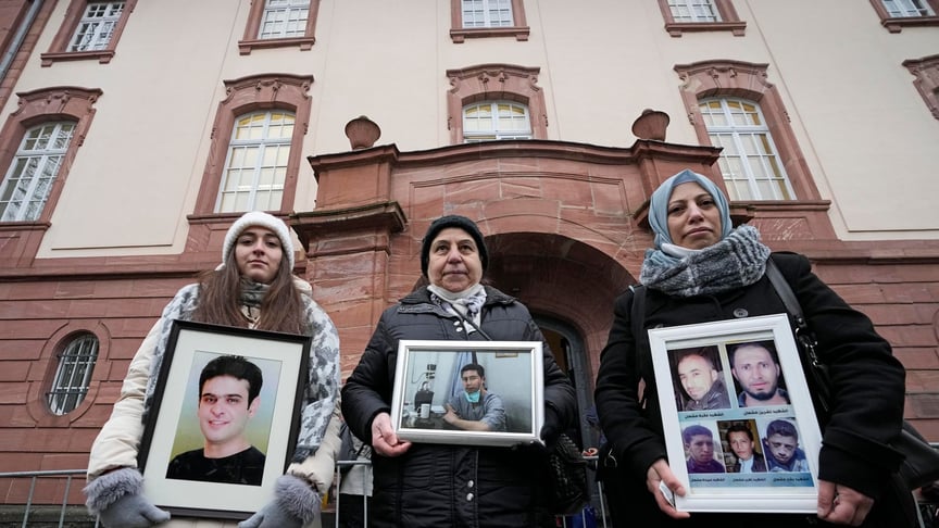 Жінки з Сирії тримають фото родичів, які загинули в Сирії, біля суду в місті Кобленц, Німеччина, 13 січня 2021 року