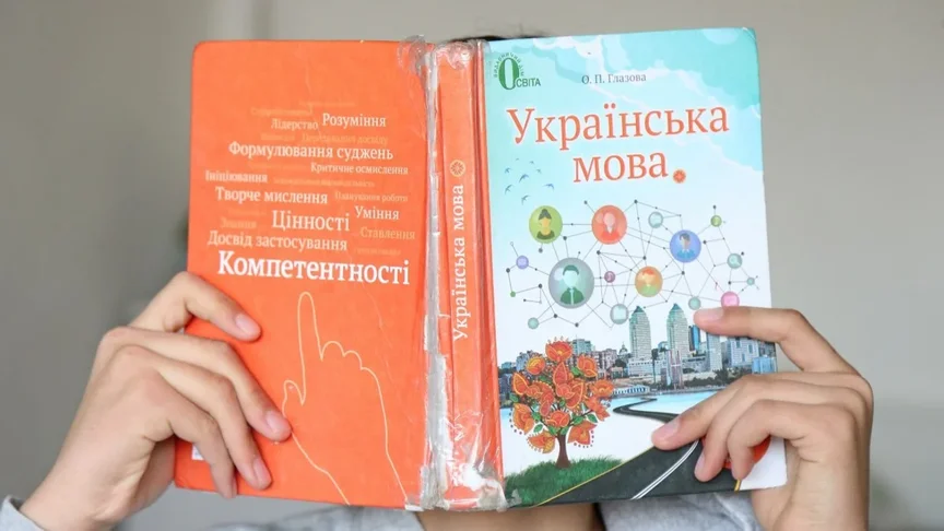 Ілюстративне фото. Учень тримає підручник з української мови