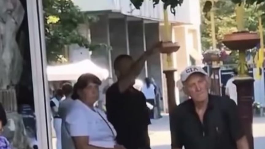 Чоловік, що показує жест, схожий на нацистський салют, під час хвилини мовчання Чоловік, що показує жест, схожий на нацистський салют, під час хвилини мовчання