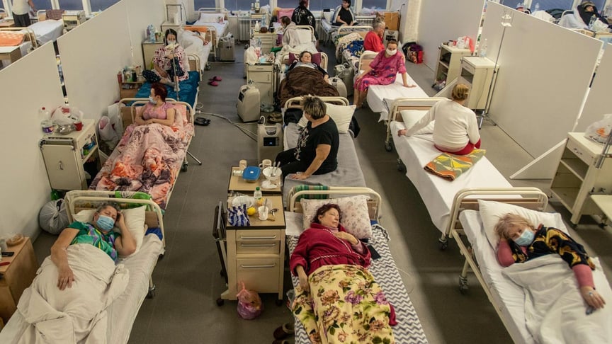 Пацієнти з COVID-19 лежать у спільному відділенні, тимчасово створеному для хворих на коронавірус у лікарні Львова, 23 березня 2021 року