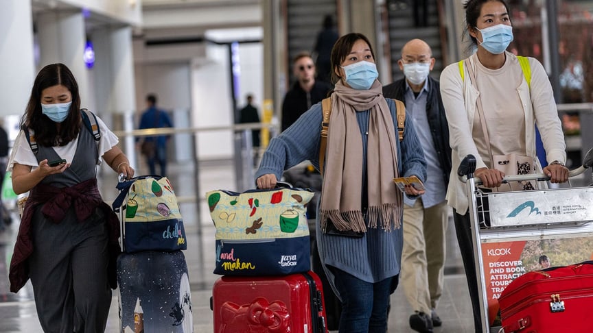 Travellers wear masks in the arrival hall of the Hong Kong International Airport in Hong Kong, China on January 22, 2020.