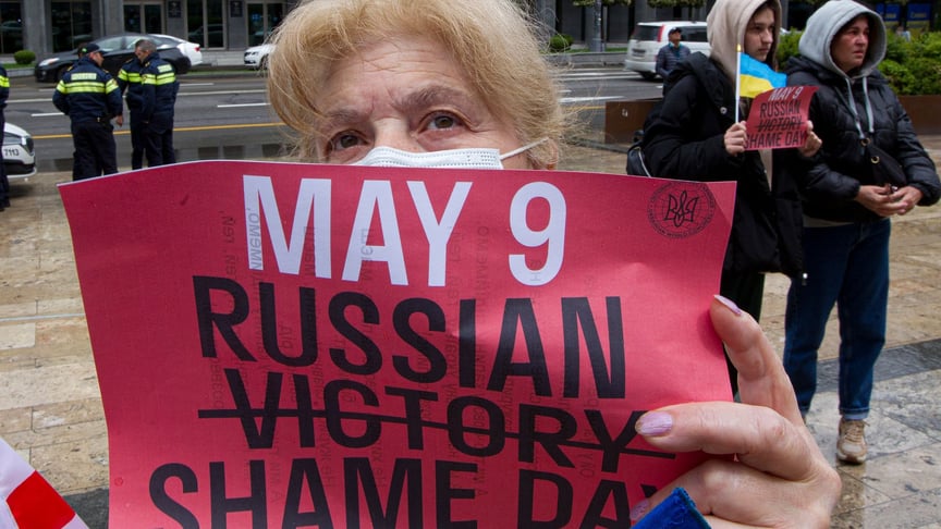 Жінка тримає плакат на антивоєнній акції протесту проти російського вторгнення в Україну у Тбілісі, Грузія, 8 травня 2022 року