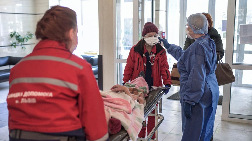 Medical worker checks the body temperature of the emergency doctors who are delivering the patient to the ward in Lviv, Ukraine on March 26.