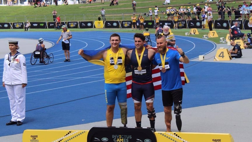 Український спортсмен, ветеран АТО Юрій Дмитренко (ліворуч) на п'єдесталі пошани