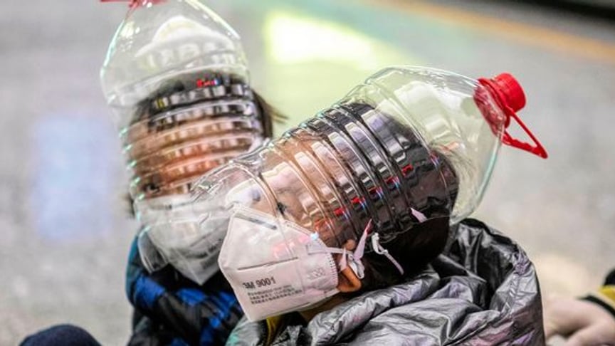 Children wear improvised face protection masks made of water bottles amid coronavirus outbreak at the airport in Guangzhou, China on February 1.