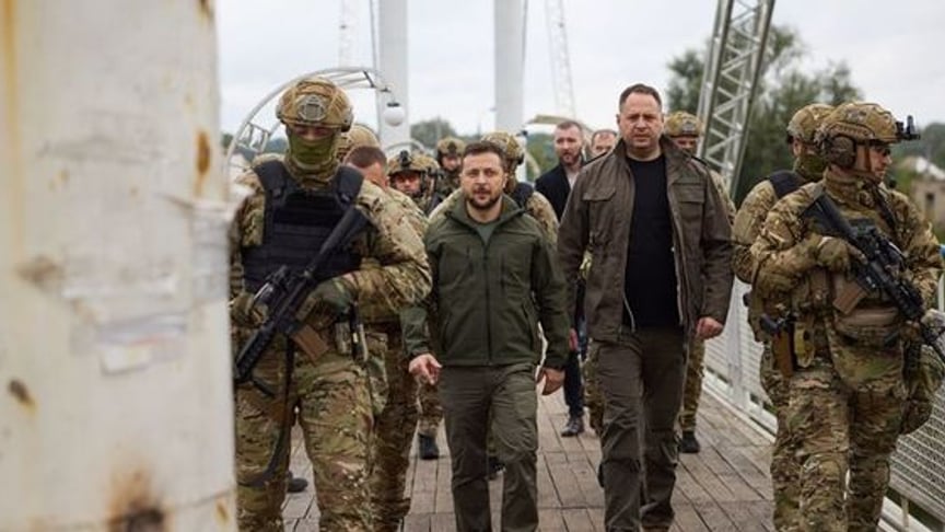 Ukrainian servicemen and Volodymyr Zelenskyy in Izium