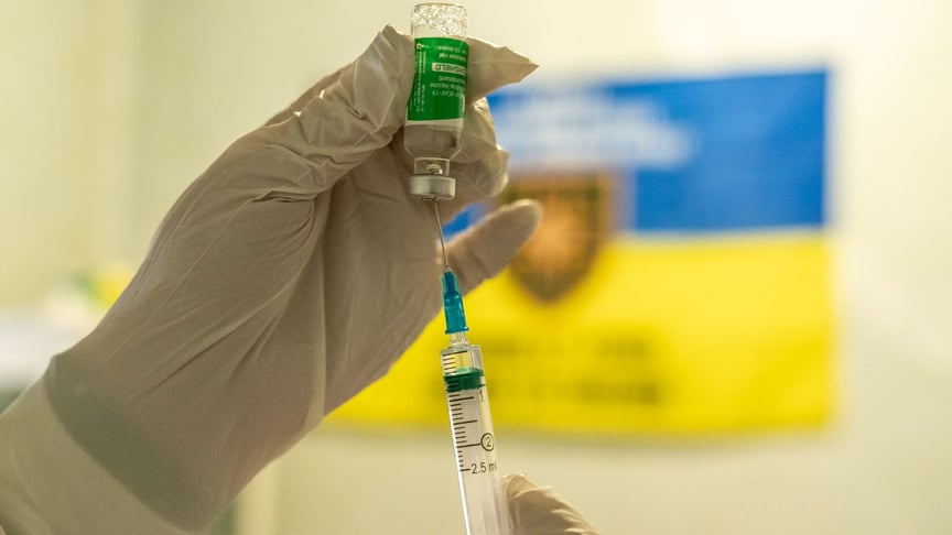 Медик готовится ввести дозу вакцины AstraZeneca