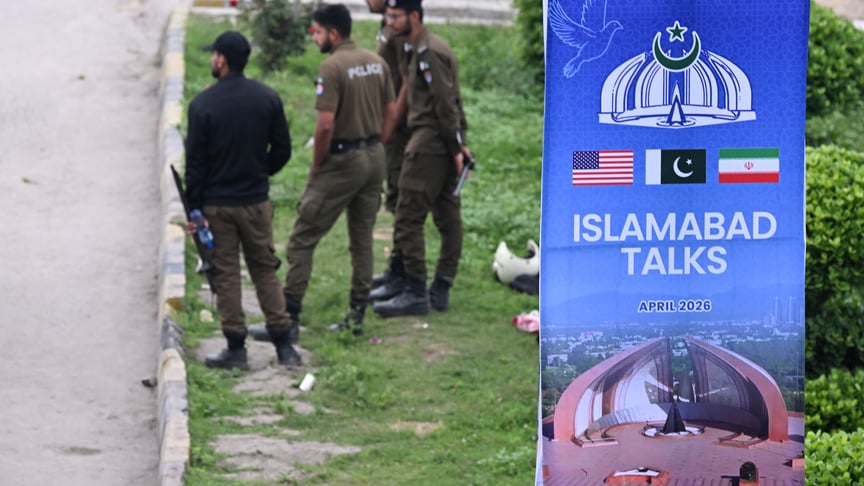 Поліціянти біля плаката, присвяченого мирним переговорам між США та Іраном в Ісламабаді, 11 квітня 2026 року