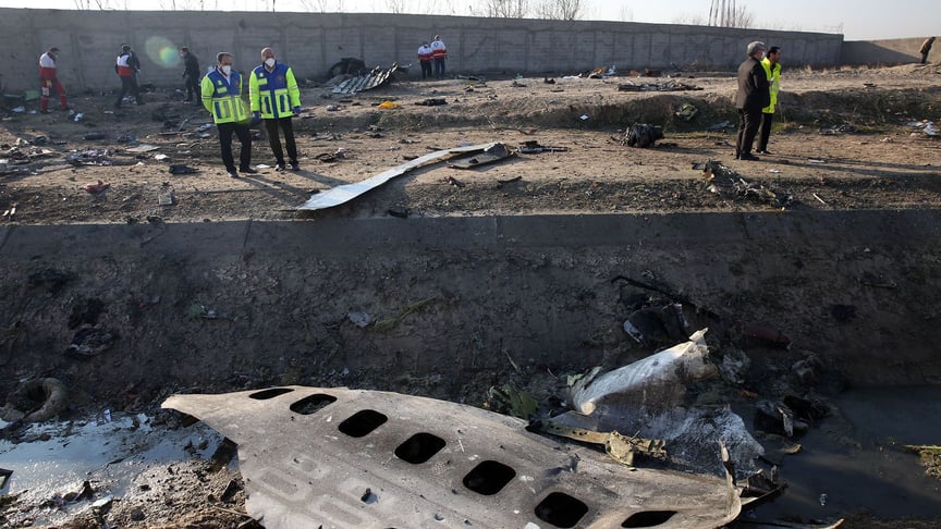 Emergency workers walk among the wreckage of a UIA plane carrying 176 people that crashed near Tehran Airport; January 8, 2020