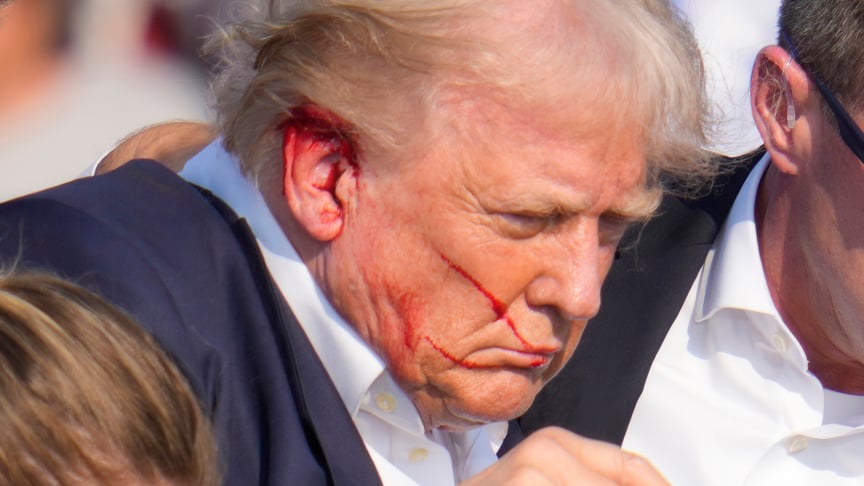 Дональд Трамп, оточений агентами Секретної служби США, спускається зі сцени на передвиборчому мітингу в Батлері, штат Пенсільванія, 13 липня 2024 року