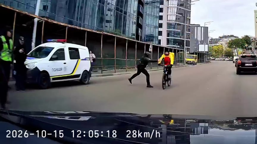 Кадр з відео, на якому поліціянт штовхає велосипедиста жезлом Кадр з відео, на якому поліціянт штовхає велосипедиста жезлом