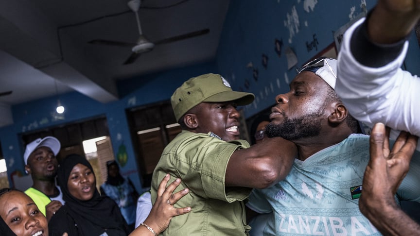 Танзанійський поліціянт зупиняє чоловіка, якого члени виборчої комісії звинуватили у спробі порушити процес голосування на виборчій дільниці в Стоун-Тауні 29 жовтня 2025 року