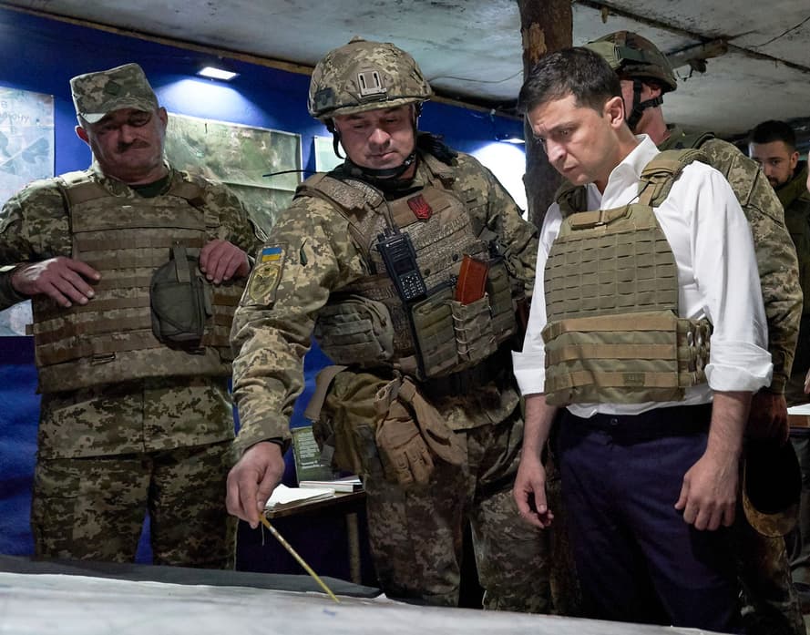 Президент Украины Владимир Зеленский слушает военнослужащего во время поездки в Донецкую область на востоке Украины